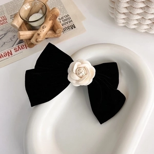 Barrette à cheveux élégante en velours noir avec camélia blanc sur plateau céramique
