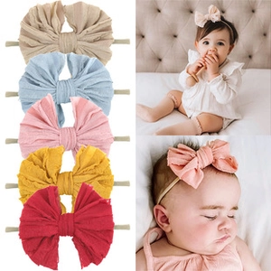 Detail of five colorful baby bow headbands with soft elastic nylon straps for infants