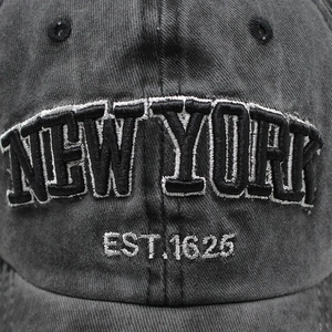 Macro shot of 3D embroidered NEW YORK lettering on washed cotton baseball cap texture