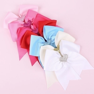 Detailed view of colorful swallowtail bows with heart gems and textured ribbon finish