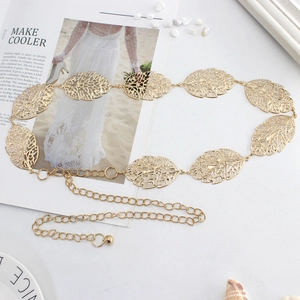 Elegant gold hollow leaf metal waist chain belt for women dresses over white pebbles