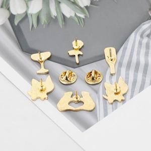 Detailed back view showing gold metal clutch butterfly pins on various cute brooches