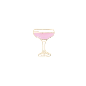 Close-up of a pink cocktail glass enamel pin with gold plating and white foam detail