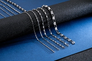 Detail of silver box chain necklaces in various thicknesses on a black display stand