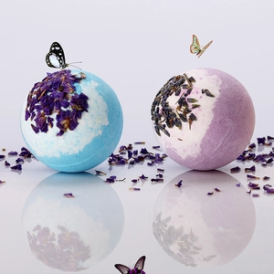 Gros plan de boules de bain aux pétales de fleurs séchées et lavande sur fond blanc