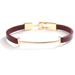 Gros plan détaillé d'un bracelet en cuir marron avec une boucle en T dorée polie