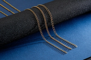 Macro view of multiple gold-toned flat curb chains in titanium steel jewelry detail