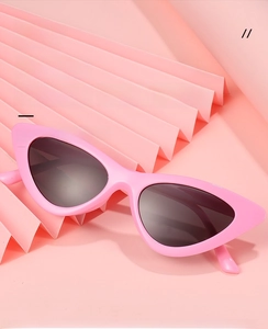 Detailaufnahme der rosa Cat-Eye Sonnenbrille mit grauen Gläsern und buntem Rahmen