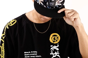 Close-up of titanium steel flat chain worn over a black graphic tee with print detail