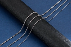 Detailed view of three silver stainless steel keel chains of different thicknesses