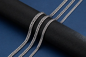 Close-up of a silver Cuban link chain with a secure lobster clasp and polished metal finish