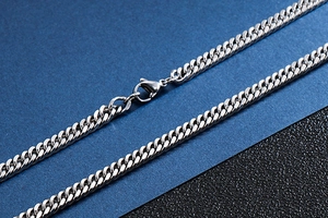 Macro detail of silver stainless steel cuban link chain with secure lobster clasp