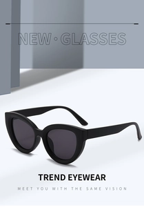 Detail shot of matte black cat-eye sunglasses with dark lenses on a modern stand