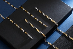 Detail of two-tone gold and silver Cuban link necklace and bracelet set on black box
