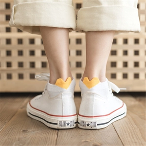 White canvas sneakers with red-blue lines paired with heart-patterned low-cut ankle socks