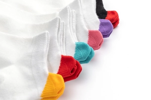 Close-up of cotton ankle socks featuring vibrant colorful heel tabs and white fabric