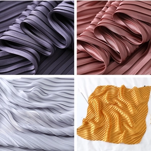 Detailed view of pleated silk scarves in dark purple, dusty pink, silver gray and gold
