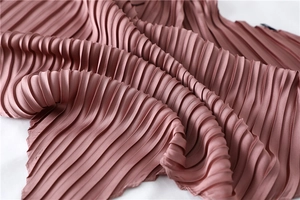 Macro detail of the elegant mauve accordion pleats fabric with a smooth satin texture