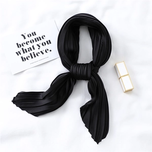 Detailed macro view of black pleated satin neck scarf with elegant silk-like glossy finish