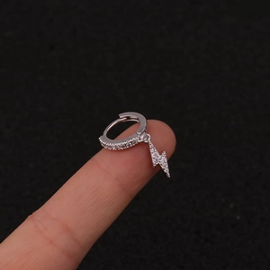 Detailed macro view of silver lightning bolt earring with sparkling cubic zirconia stones