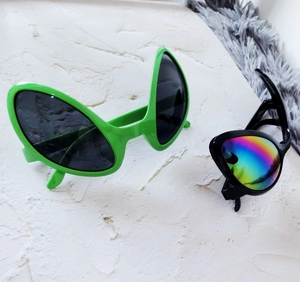 Top view of funny alien shaped party sunglasses in green and black plastic frames