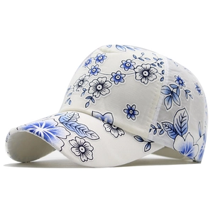 Dettaglio ravvicinato del cappellino bianco traspirante con eleganti ricami floreali blu