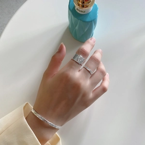 Close-up of S925 sterling silver rings with irregular hammered texture on female hand