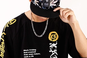 Detail of silver link chain necklace paired with street style printed black t-shirt