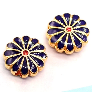 Detailed macro of golden enamel sunflower bead with blue petals and red center for DIY