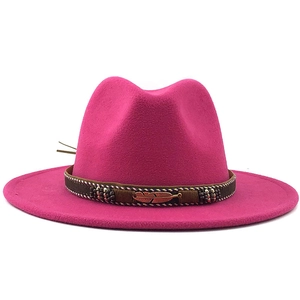 Detail of rose pink wool fedora hat featuring woven band and gold metal feather charm