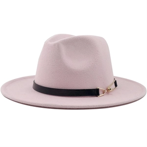 Detail of pink fedora hat featuring a black leather band and gold metal buckle accent