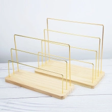 Close-up of tiered wood and gold metal jewelry display stands for necklaces and cards