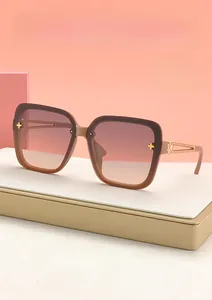 Detail of square sunglasses with brown gradient lenses and golden floral hinge accents