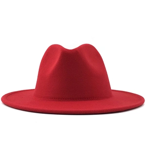 Detail of red wool fedora with wide brim and precise stitching on white background
