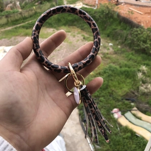 Close-up of leopard print keyring bangle with pink charm and gold spring clasp