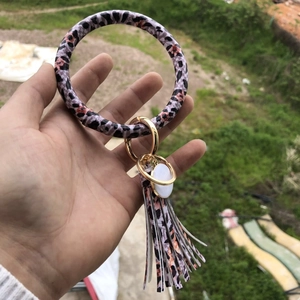 Detail of leopard and floral PU leather wristlet keychain with gold metal ring and tassel