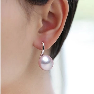 Macro view of pink freshwater pearl earrings with silver high-heel hook on a model