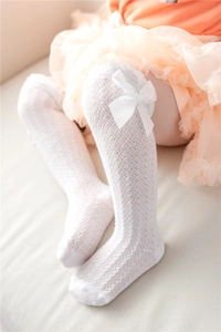 Detail of white mesh baby knee high socks with breathable lace and silk bow decoration
