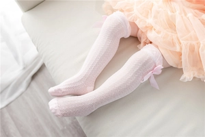 Detail of pink mesh baby knee-high socks featuring a delicate satin bow and breathable texture
