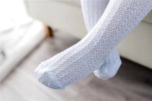 Detailed macro view of light blue baby socks with breathable hollow lace mesh texture
