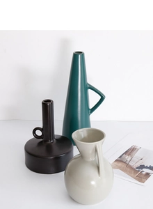 Detail of matte ceramic vases in Nordic Morandi tones with unique geometric handles
