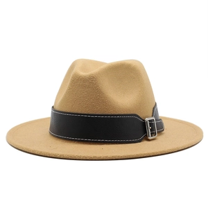Detail of khaki wool fedora hat featuring a black leather band with white stitching and silver buckle