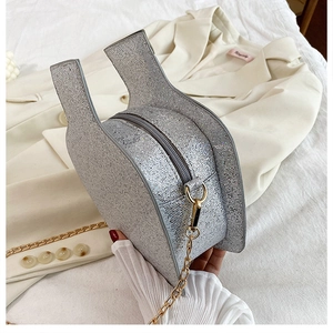 Detail of silver sequined heart crossbody bag with gold chain strap and zipper