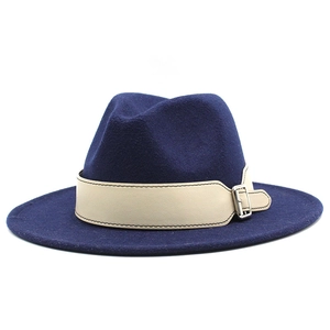 Detailed side view of navy fedora hat with beige leather band and silver metal buckle