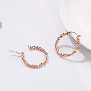 Elegant rose gold beaded hoop earrings featuring a polished 39mm stainless steel design