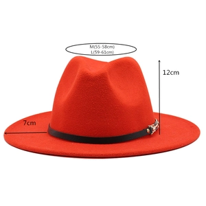 Detail of red fedora hat showing size measurements, belt buckle, and wool felt texture