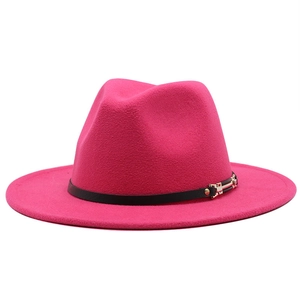 Detail of magenta wool fedora hat featuring a black leather band and gold metal buckle