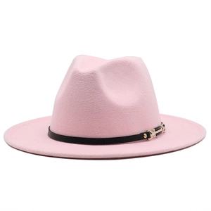 Detailed close-up of a pink wool fedora with a black leather band and gold buckle accent
