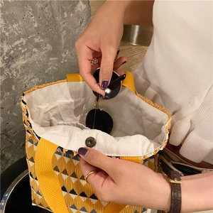 Dettaglio della borsa a mano plissettata a fiori con fibbia magnetica in bronzo e fodera beige