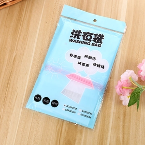 Close-up of retail packaging for a 30x40cm mesh laundry bag on a light wood background